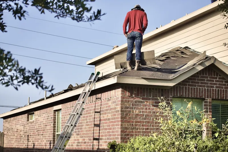 Professional roofer working on a residential roof in Stone Barn Station